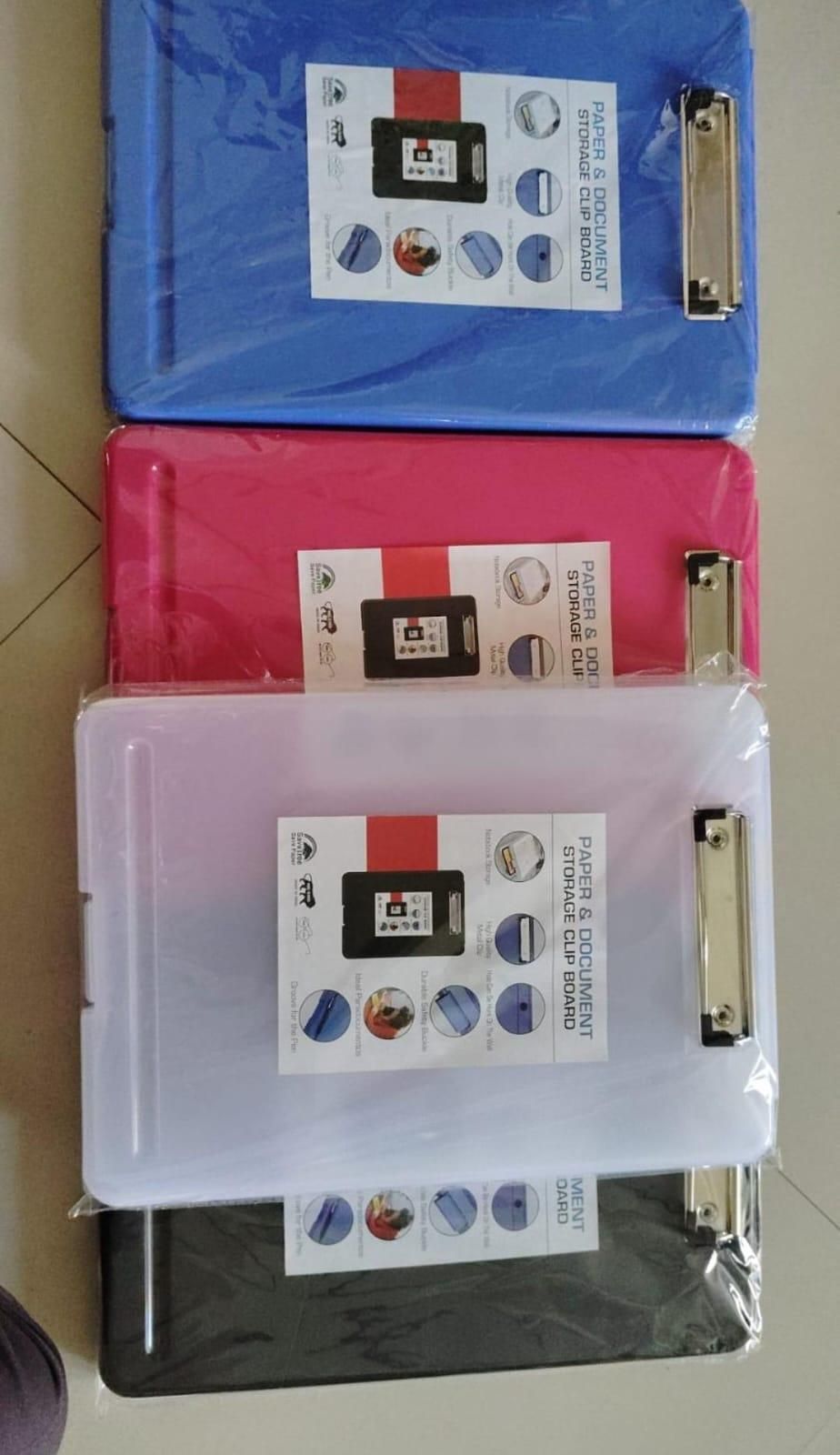 Set of binders with colorful covers and clip bars on a surface.