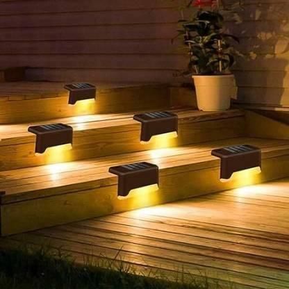 Solar-powered outdoor lights on wooden steps with a potted plant in the background.