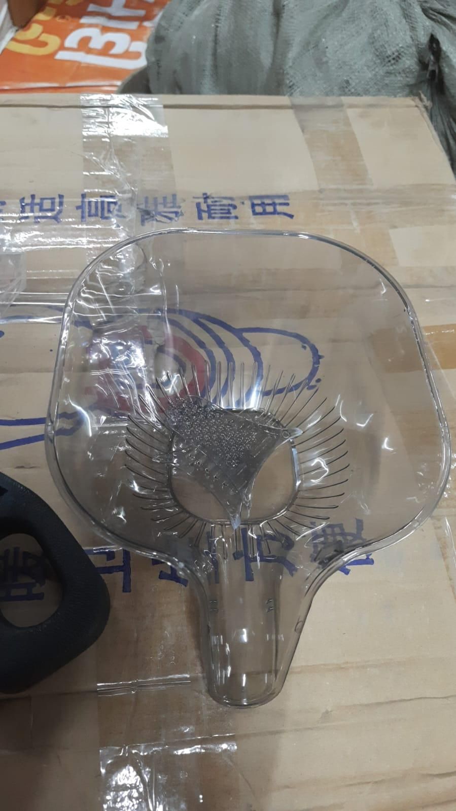 Clear plastic scoop on a wooden surface with a blurred background
